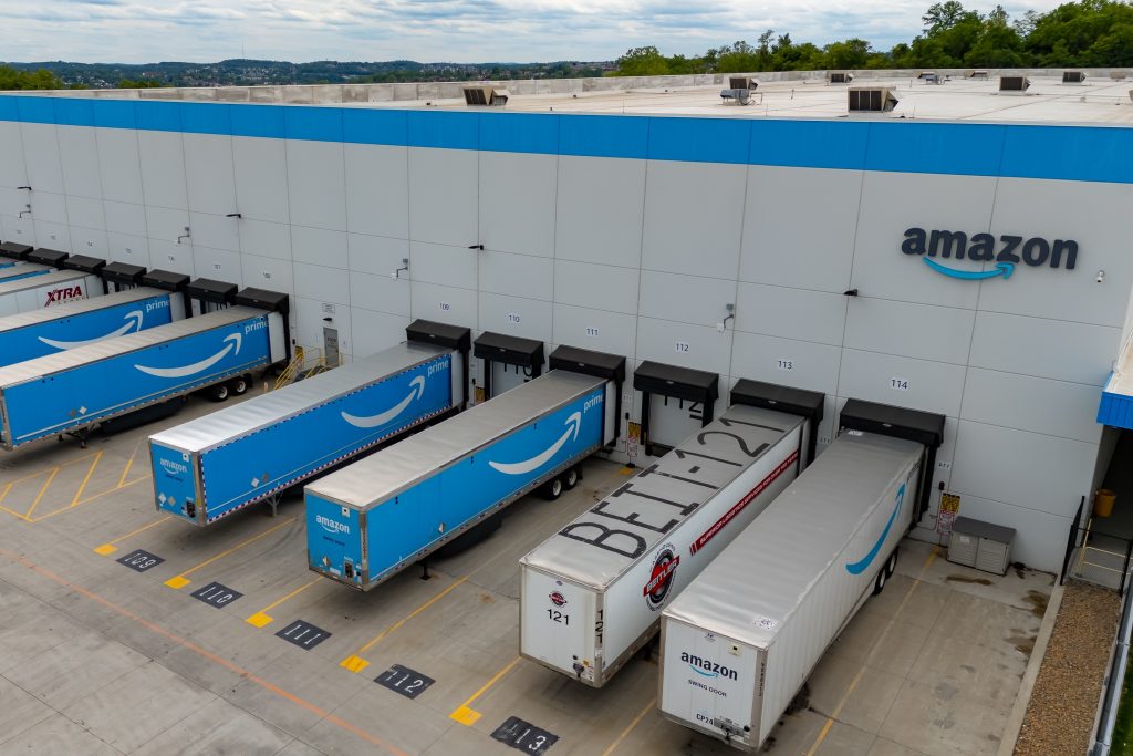 Un centre de distribution Amazon avec des camions de livraison, illustrant le lancement d'Amazon Supply Chain Services ouvert aux entreprises de tous secteurs