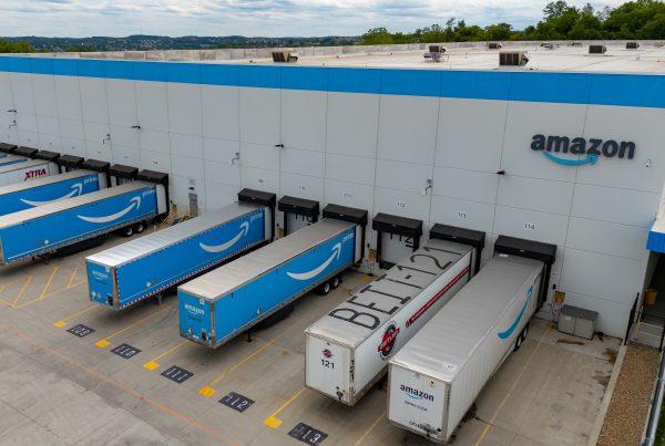 Un centre de distribution Amazon avec des camions de livraison, illustrant le lancement d'Amazon Supply Chain Services ouvert aux entreprises de tous secteurs