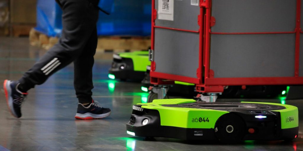 Robot autonome Proteus d'Amazon circulant dans un entrepôt logistique européen aux côtés d'employés